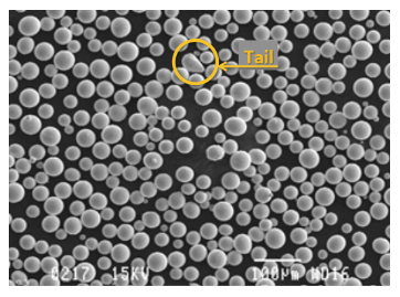 Microscopic view of solder spheres. Many mostly spherical gray spheres, with one misshapen one circled.