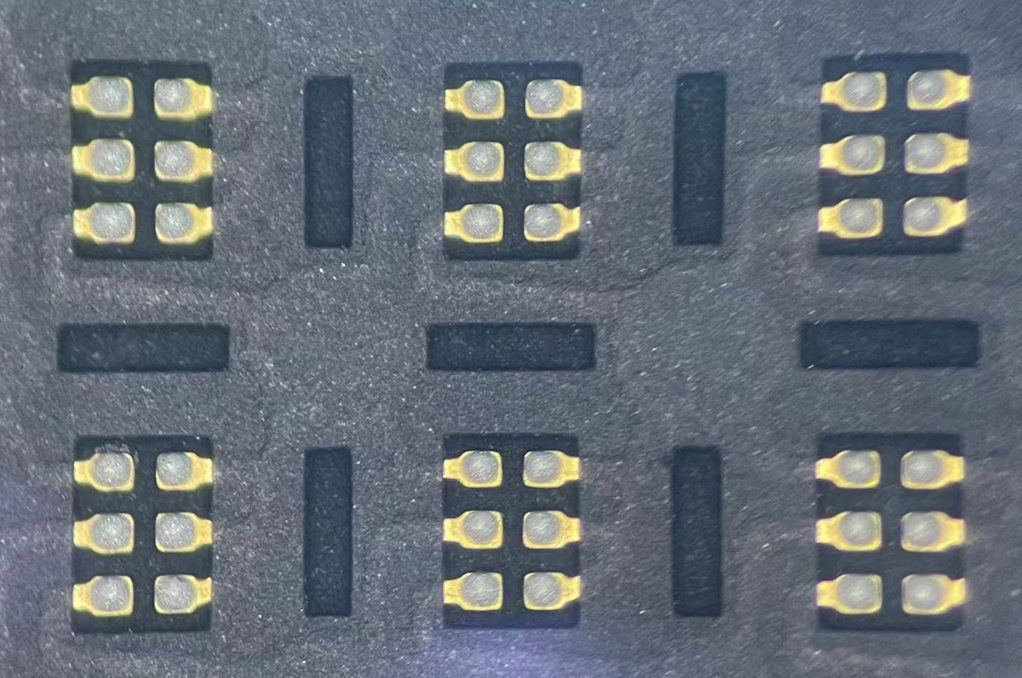 A close-up view of solder paste printed on metal pads.